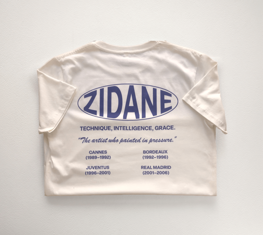 Back view of the Zidane Essentials Tee showcasing a printed timeline and the quote: “The artist who painted in pressure.”
